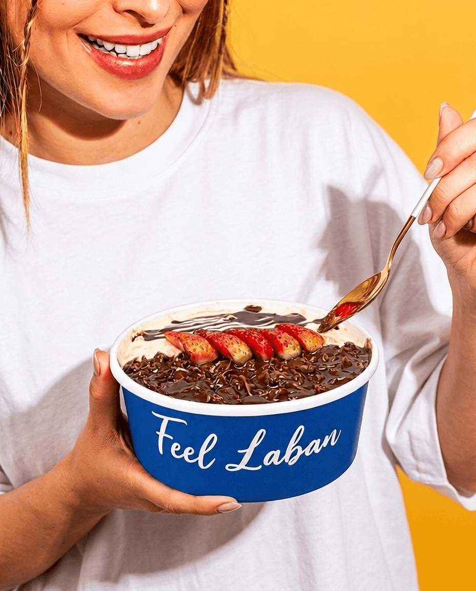 A smiling guest holding a Feel Laban chocolate and strawberry bowl